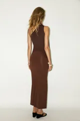 Falda midi color marrón chocolate, de tiro alto con cintura elástica, detalle de frunces en un lateral y abertura frontal.