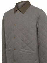 Chaqueta acolchada gris con patrón de rombos, cuello de pana marrón, cierre con broches metálicos, bolsillos frontales y bolsillo interno.