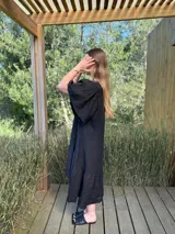 Vestido largo color beige, de corte amplio, con mangas cortas abullonadas y volado en el ruedo.