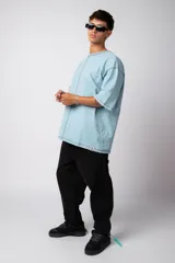 Remera negra oversize con mangas cortas y costuras a la vista en color blanco.