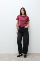 Remera de manga corta color bordó con cuello redondo y pequeños ojalillos metálicos decorativos en los bordes de las mangas.