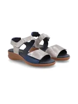 Sandalia de cuero azul con apliques plateados y suela marrón.