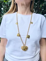 Collar largo dorado con cadena de eslabones y dijes de corazones texturizados.