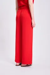 Pantalón de vestir rojo de corte palazzo, con cintura elastizada y lazo ajustable.