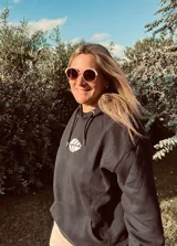 Hoodie negro de corte oversize con cordones ajustables y estampado frontal de una hoja blanca.