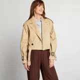 Gabardina corta color beige con cuello solapa, manga larga con trabillas ajustables, cierre cruzado con botón y cinturón.