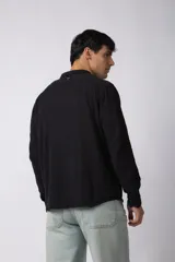 Camisa de lino blanca de manga larga, con cuello clásico y cierre frontal con botones. Corte recto y holgado.