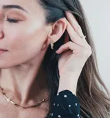 Par de aros tipo argolla dorados con circonitas incrustadas.