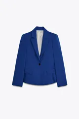 Blazer azul eléctrico de corte entallado, con cuello de solapa, manga larga con hombreras, bolsillos frontales con solapa y cierre frontal con un botón.