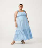 Vestido largo celeste de viscosa, con escote redondo, tirantes anchos con volantes, fruncido en el busto y volado en el ruedo.