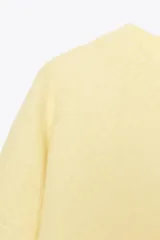 Jersey color amarillo pastel de punto liso, con cuello redondo y manga larga.
