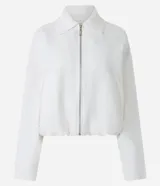 Campera blanca de viscolino, modelo globo, con cuello camisero, manga larga, cierre delantero y bolsillos fake.