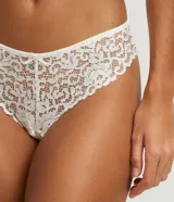 Bombacha de lencería femenina color blanco, modelo bikini hilo, confeccionada en encaje floral. Presenta un diseño cavado en la parte trasera y detalles de encaje en los bordes.
