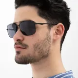 Lentes de sol INVU con montura metálica negra, forma cuadrada y lentes polarizadas grises.