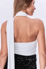 Top blanco de un solo hombro con cuello alto drapeado.