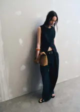 Chaleco negro con cierre de botones en la parte delantera, cuello redondo, sin mangas y forro interior.