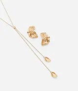 Conjunto de bisutería en baño dorado que incluye un collar estilo corbata con cadena tipo serpiente y dijes en forma de flor, junto con un par de caravanas con diseño de media flor orgánica.