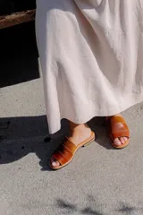 Sandalias de cuero negras con diseño de tiras cruzadas y detalle de elástico en el talón.