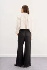 Pantalón palazzo negro de tiro alto con cintura elastizada y bolsillos diagonales.