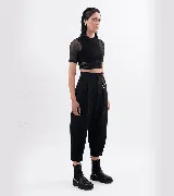 Pantalón sastre corte babucha color negro, con tablas, detalle de argolla metálica delantera y trasera, y tiro alto.