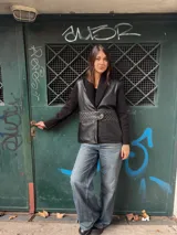 Chaqueta negra con cuerpo de cuero, mangas de tejido de punto y cuello de lana.