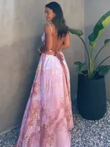 Vestido largo de tela fluida, color verde esmeralda con estampado abstracto en tonos turquesa y detalles dorados. Diseño asimétrico con un solo tirante tejido en el hombro.