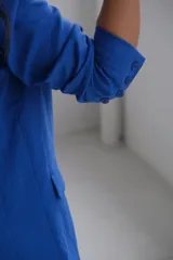 Blazer azul de lino, con solapa de muesca, cierre frontal con botones y bolsillos laterales.