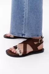 Sandalias negras con tiras cruzadas de cuero y pelo vacuno con estampado animal print.