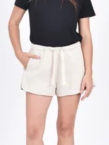 Short de algodón color beige, con cintura elástica ajustable con cordón y bolsillos laterales.