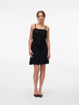 Falda corta de punto calado color negro, con cintura elastizada y lazo ajustable.