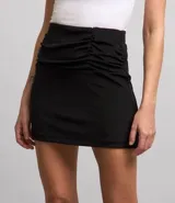 Minifalda negra con efecto cruzado y fruncido lateral.