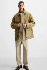 Pantalón de hombre color beige, corte carrot fit, con cintura elástica ajustable con cordón, bolsillos frontales y bolsillo trasero de plastrón.
