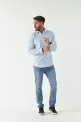 Camisa celeste a cuadros, de corte slim fit, manga larga y logo bordado. Confeccionada en 100% algodón.