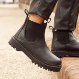 Bota negra de cuero con caña media, forro de cuero, plantilla de cuero con espuma confort y suela de 3 cm de altura.