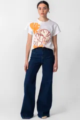 Remera blanca de algodón con cuello redondo y mangas cortas. Estampado frontal con flores en tonos naranja y bordó, y logo de la marca en el ruedo.