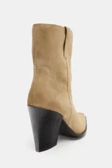 Botín de piel estilo cowboy con detalle de pespuntes en el cuerpo, tiradores laterales, tacón alto en bloque y acabado en punta.