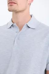 Remera manga corta verde con cuello polo y tapeta con botones.