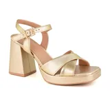 Sandalias de cuero color beige con plataforma y taco cuadrado. Presentan tiras cruzadas en el empeine y pulsera con hebilla al tobillo.