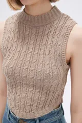 Chaleco verde pálido de punto con cuello alto y diseño trenzado.