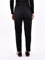 Jeans de mujer color negro lavado, tiro alto, con corte recto o ligeramente cónico y largo al tobillo.