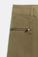 Jeans cargo de tiro medio color verde militar, con pernera recta. Presenta bolsillos laterales de plastrón con cierre de cremallera y cierre frontal con cremallera y botón.