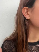 Set de tres aros dorados con incrustaciones de circonias. Incluye un aro solitario y dos aros tipo argolla con circonias engarzadas.