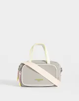 Cartera bowling gris claro de tela deportiva con bolsillo frontal y tag de goma. Tiene correa regulable desmontable, manijas superiores, cierre superior, bolsillo frontal con cierre y puller de cordón y goma, y mosquetón lateral con cordones decorativos.