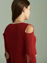 Saco de algodón verde con aberturas en hombros y codos, de corte entallado. Tiene cuello en V, botones pequeños y plaqueta de tejido puño color crudo.