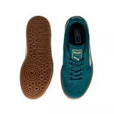Championes Puma Palermo Elevata, color negro con franja blanca y suela marrón.