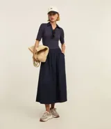 Vestido midi con corte godê, confeccionado en rib de viscosa en la parte superior y tricolina de algodón en la falda. Presenta cuello polo y mangas cortas.