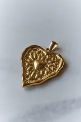 Collar con tiento encerado negro y dije dorado con forma de corazón texturizado.