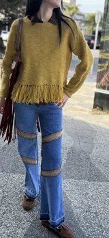 Sweater tejido en lana color borgoña, con cuello redondo y terminación con flecos.