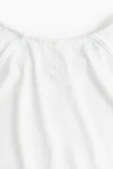 Remera deportiva blanca de corte holgado, cuello redondo y mangas raglán cortas. Confeccionada en tejido funcional DryMove™ con detalle reflectante en la espalda.