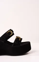 Sandalias negras de plataforma con dos tiras anchas de gamuza y hebillas doradas.